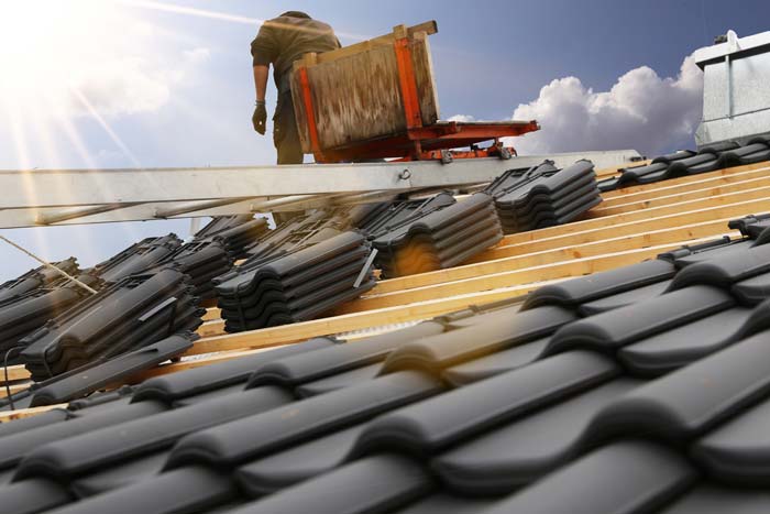 Roofer re-tiling a rooftop